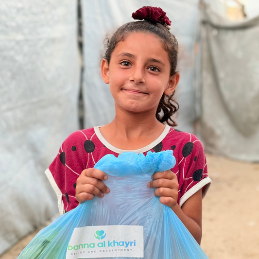 Girl holding a bag of vegetables with 'Al Khayri' branding
