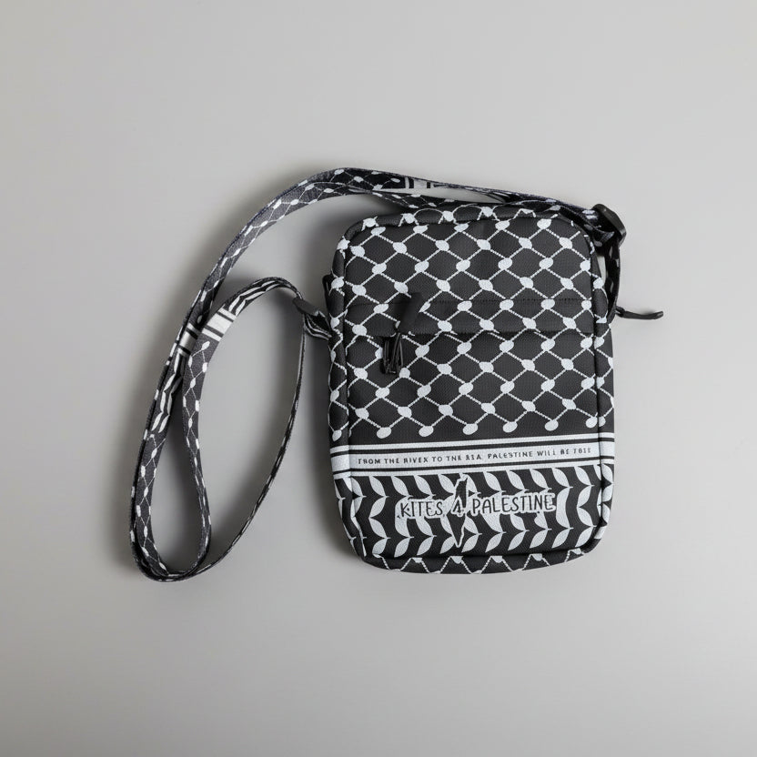 Black and white patterned bag with 'Kisses for Palestine' text on a textured surface